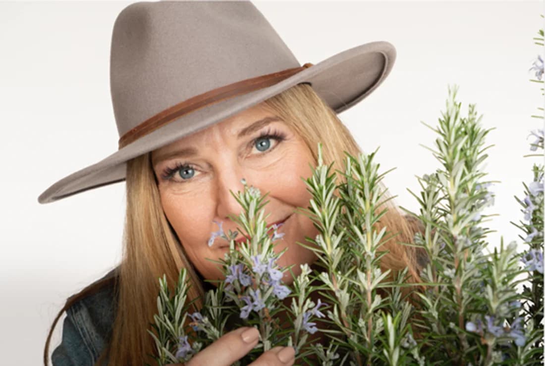 Kari Warberg Block, EarthKind founder, with fresh herbs behind the plant-based pest control brand