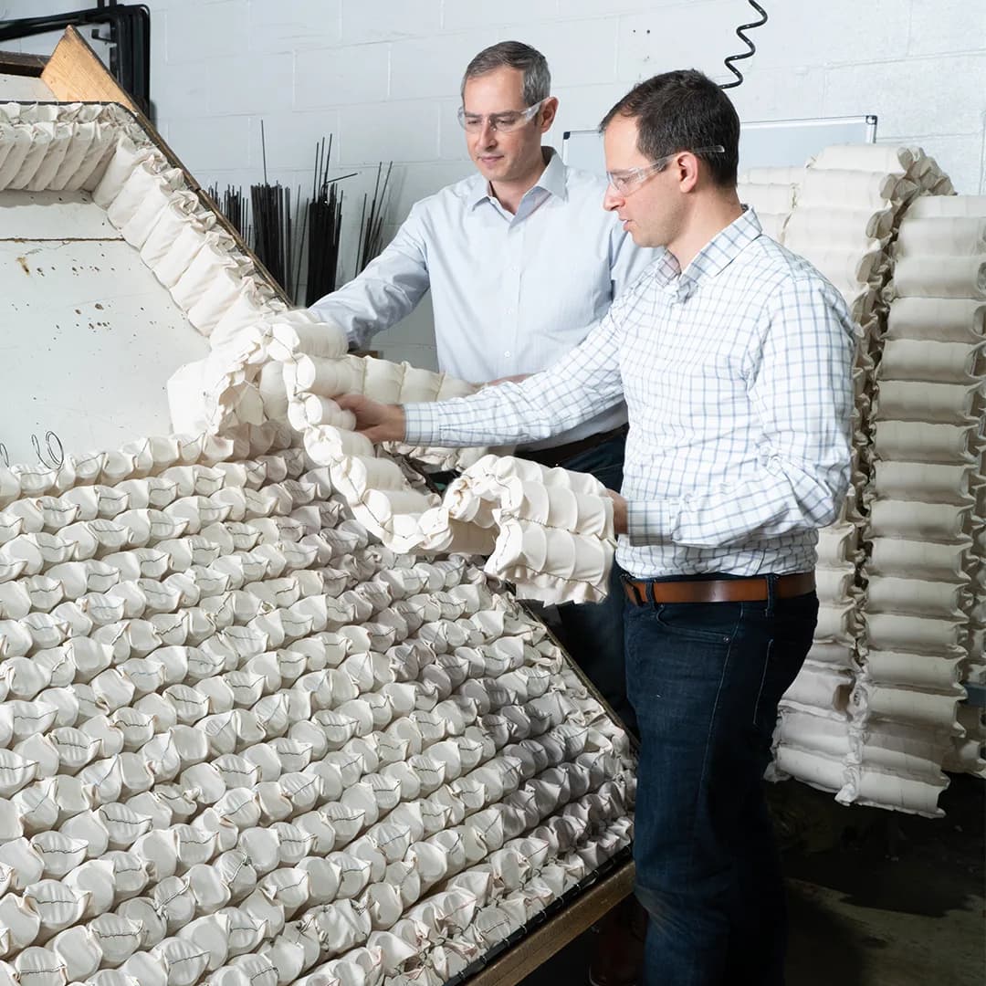 Naturepedic team inspecting hand-crafted crib mattress construction